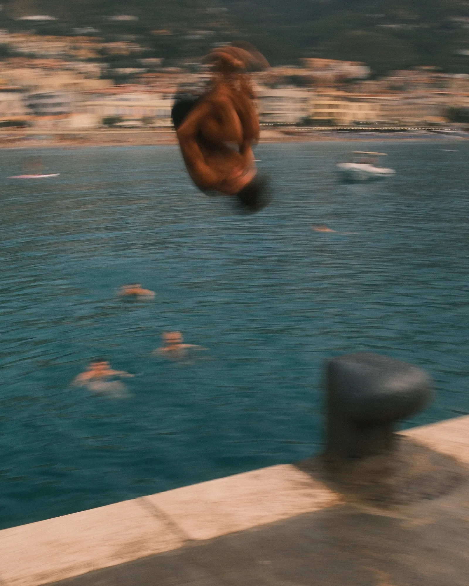 A kid backflipping into the water in Cefalù