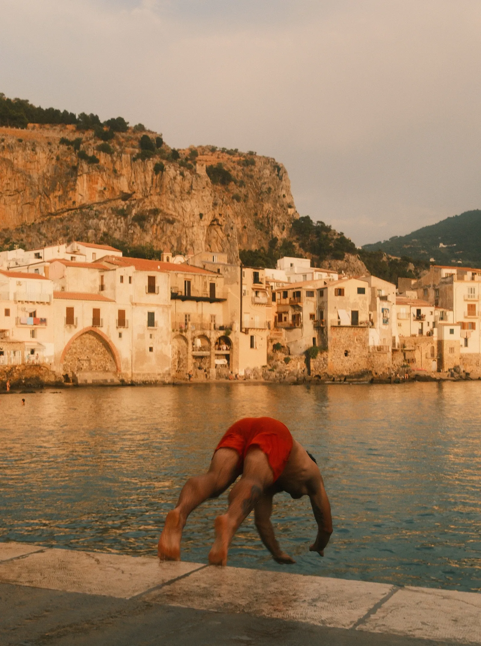 A man jumping into the water in Cefalù